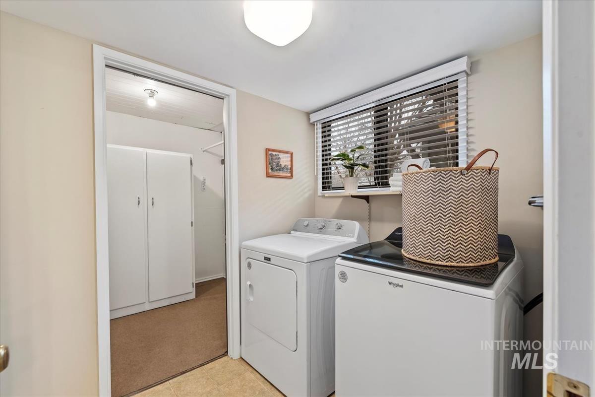 Laundry area with independent washer and dryer and light floors