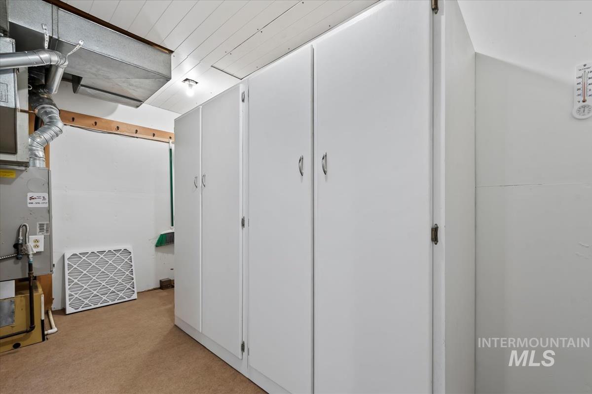 Basement featuring light colored carpet and heating unit