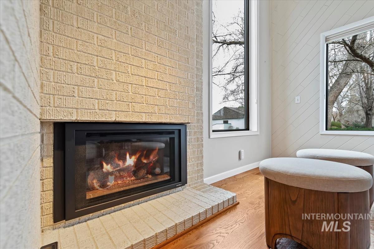 Detailed view of wood finished floors, a fireplace, and wooden walls