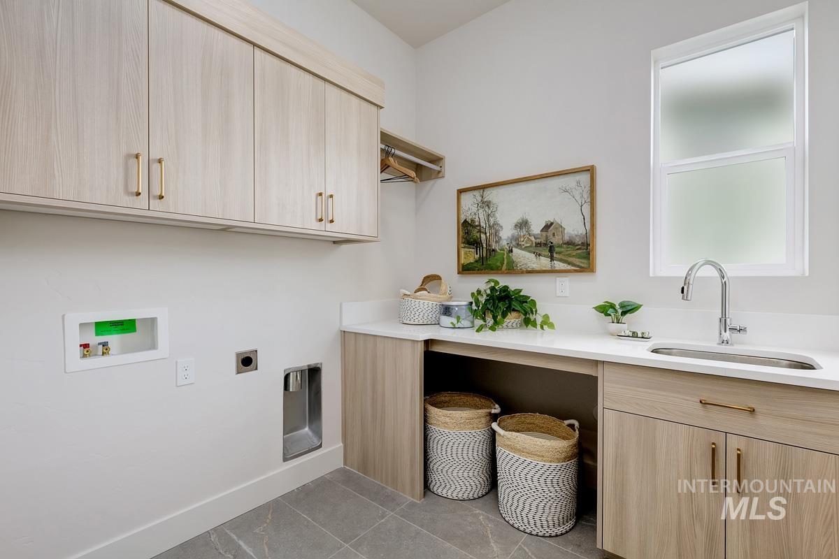 Washroom with light tile patterned flooring, hookup for an electric dryer, cabinet space, and hookup for a washing machine