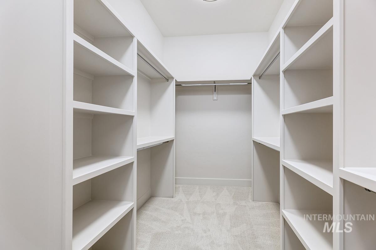 Spacious closet with light carpet