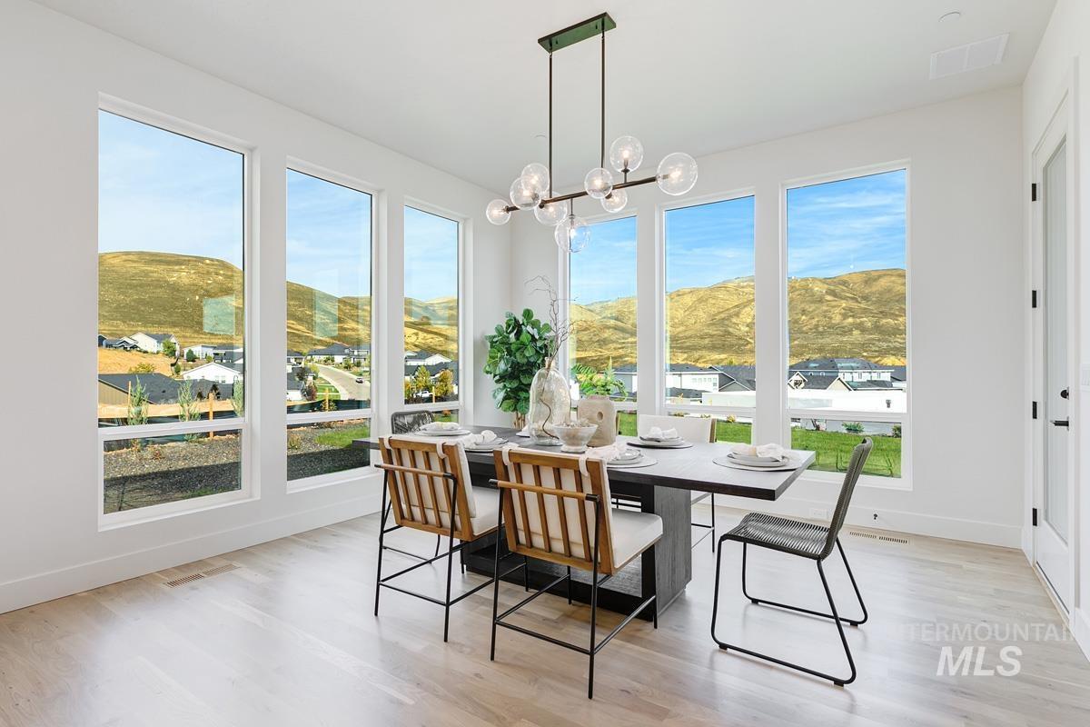 Sunroom / solarium with a mountain view, plenty of natural light, and a chandelier