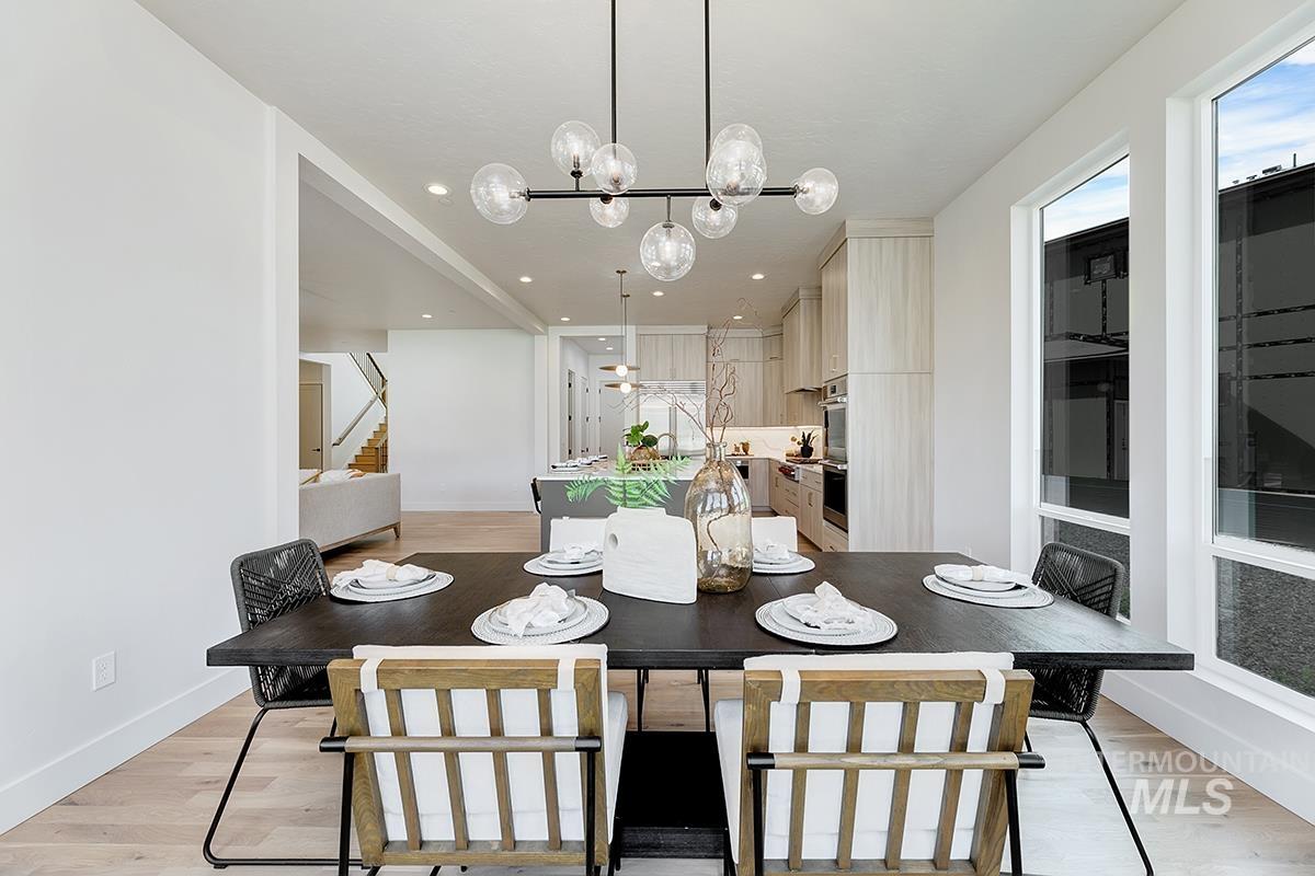 Dining room with light wood-style floors, stairs, a chandelier, and recessed lighting