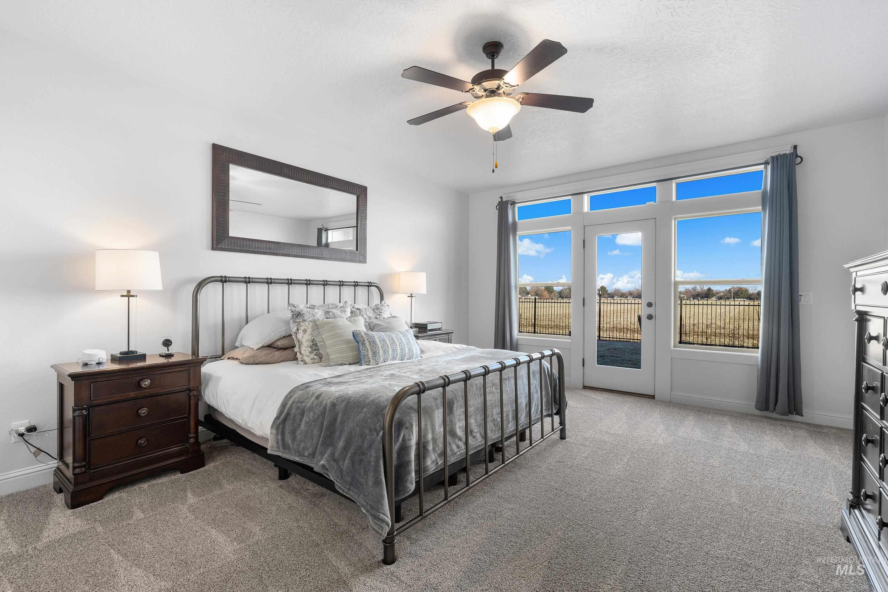Bedroom with access to outside, a ceiling fan, and light carpet