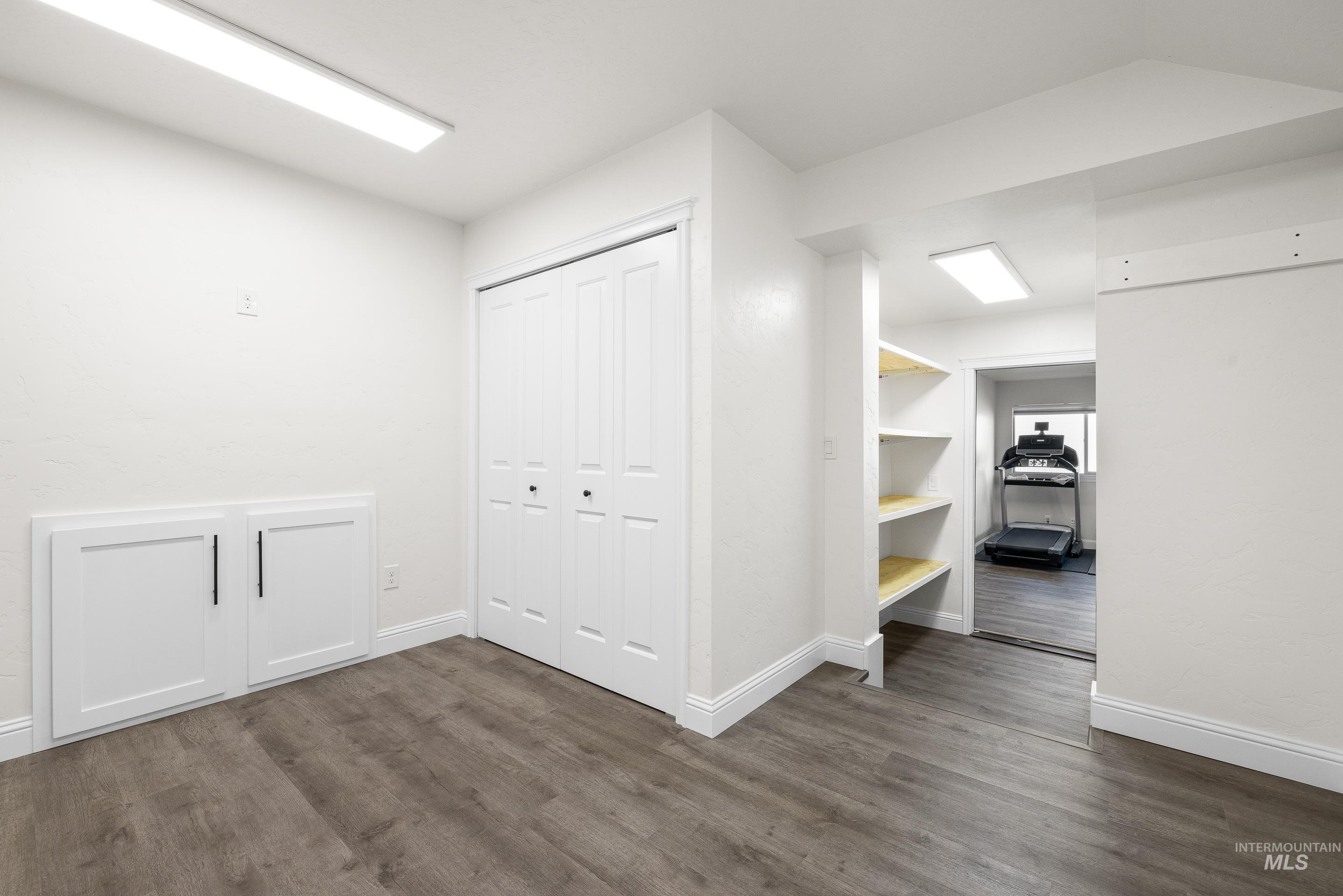 Unfurnished bedroom featuring dark wood-type flooring and a closet