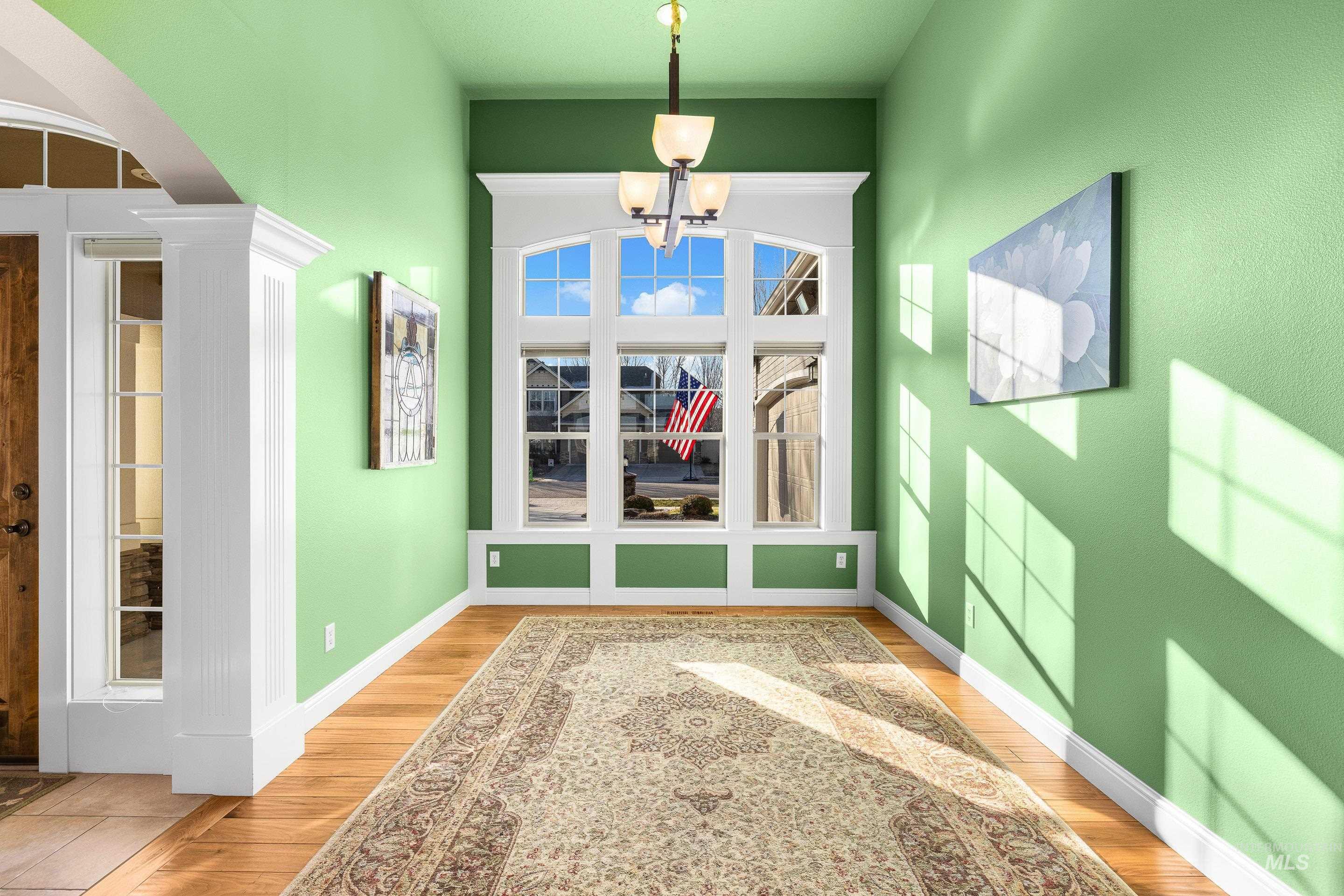 Unfurnished dining area with light wood finished floors, arched walkways, and a chandelier