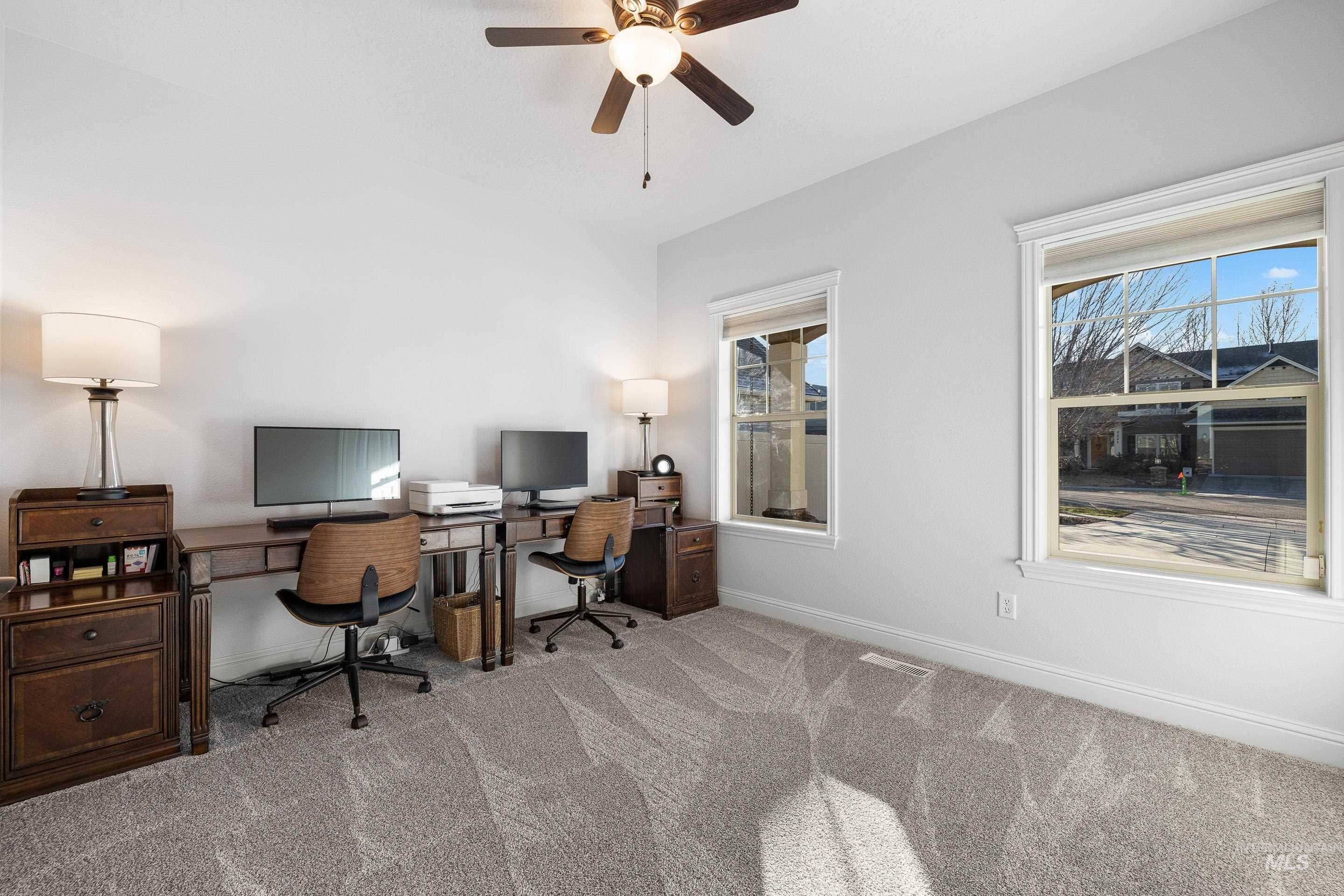 Home office with carpet and a ceiling fan