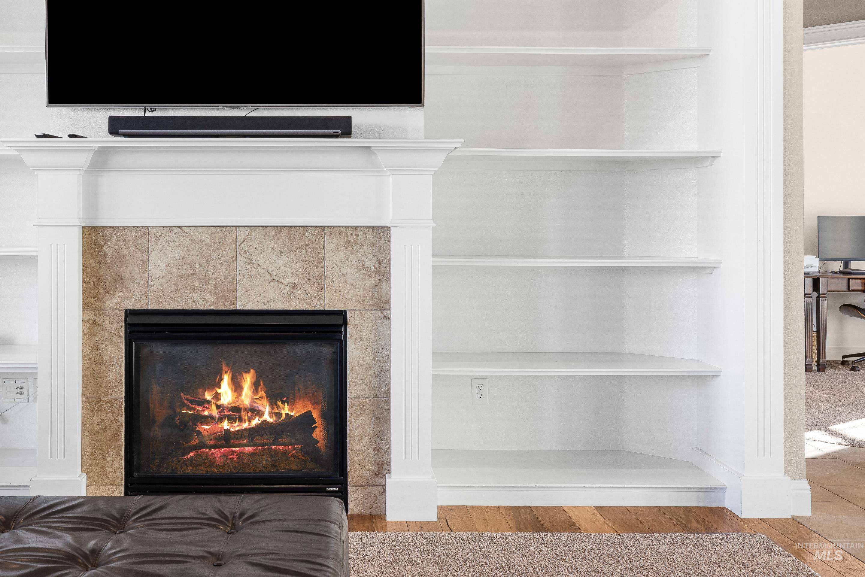 Detailed view of wood finished floors and a fireplace