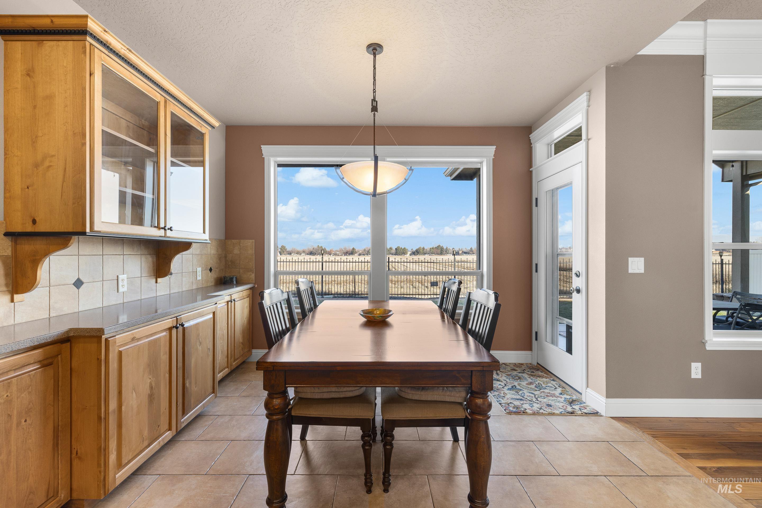 Dining area featuring a textured ceiling, healthy amount of natural light, and light tile patterned flooring