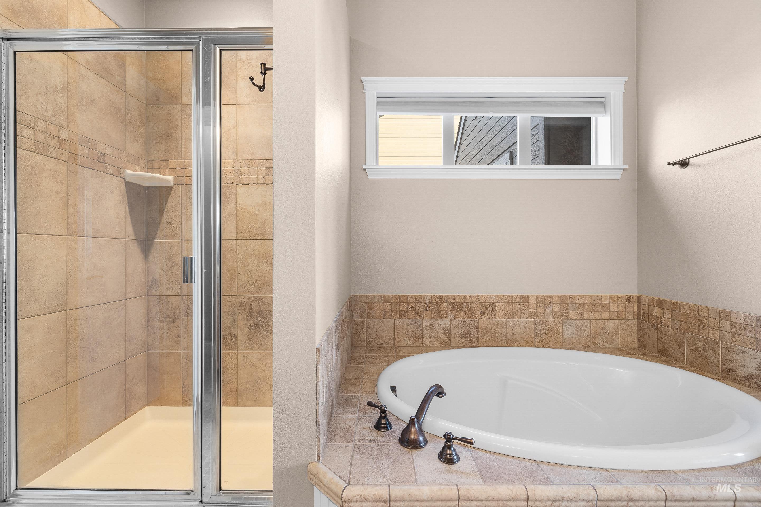 Full bath featuring a garden tub and a shower stall