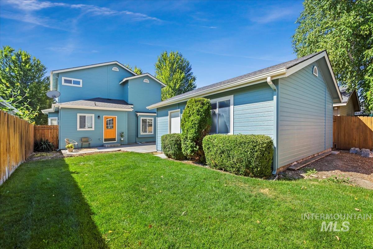 Rear view of property with a fenced backyard and a patio