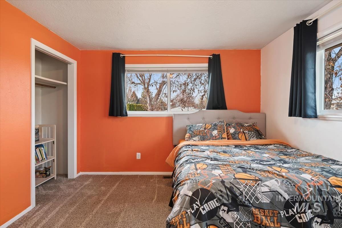 Bedroom featuring dark carpet, a closet, and a textured ceiling