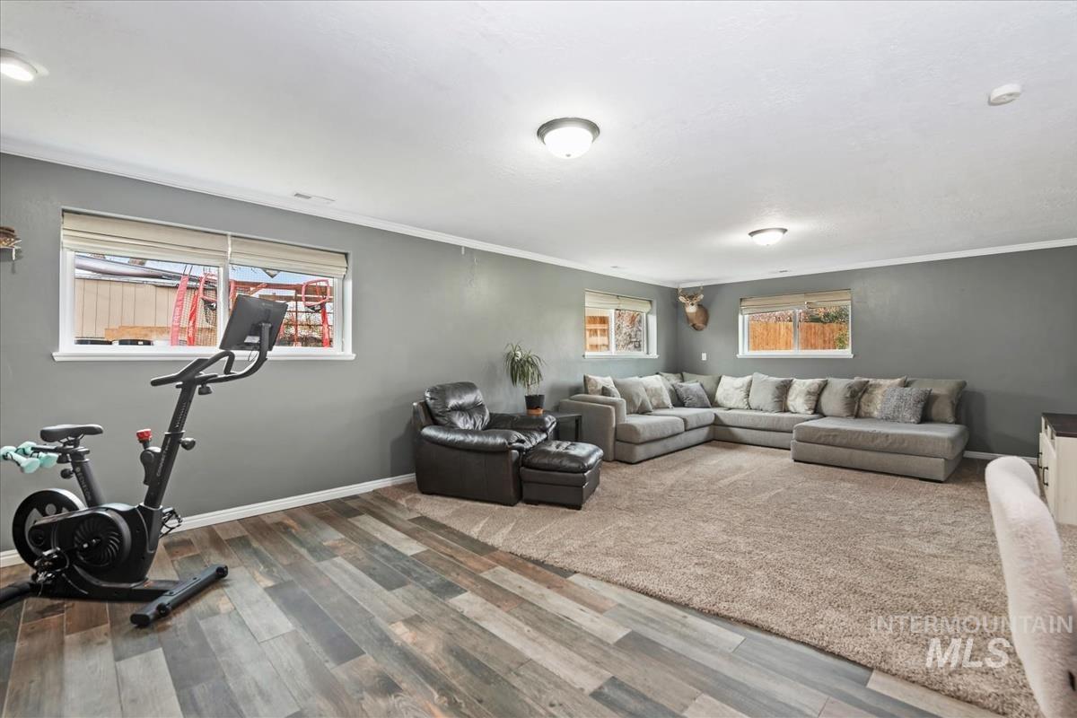 Living room featuring wood finished floors and crown molding