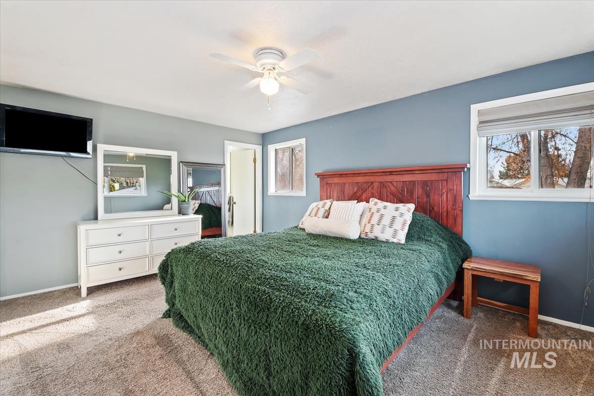 Carpeted bedroom featuring baseboards and ceiling fan