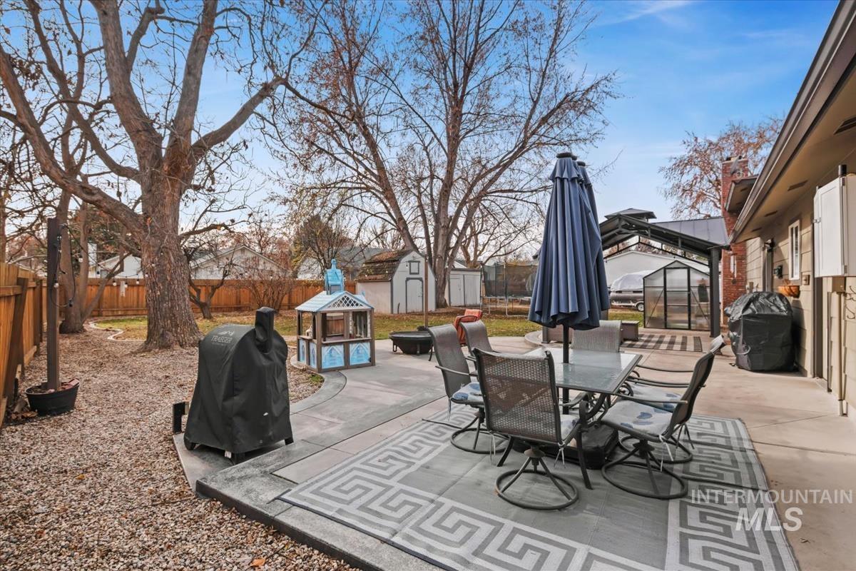 Fenced backyard with a gazebo, a patio area, outdoor dining area, and grilling area