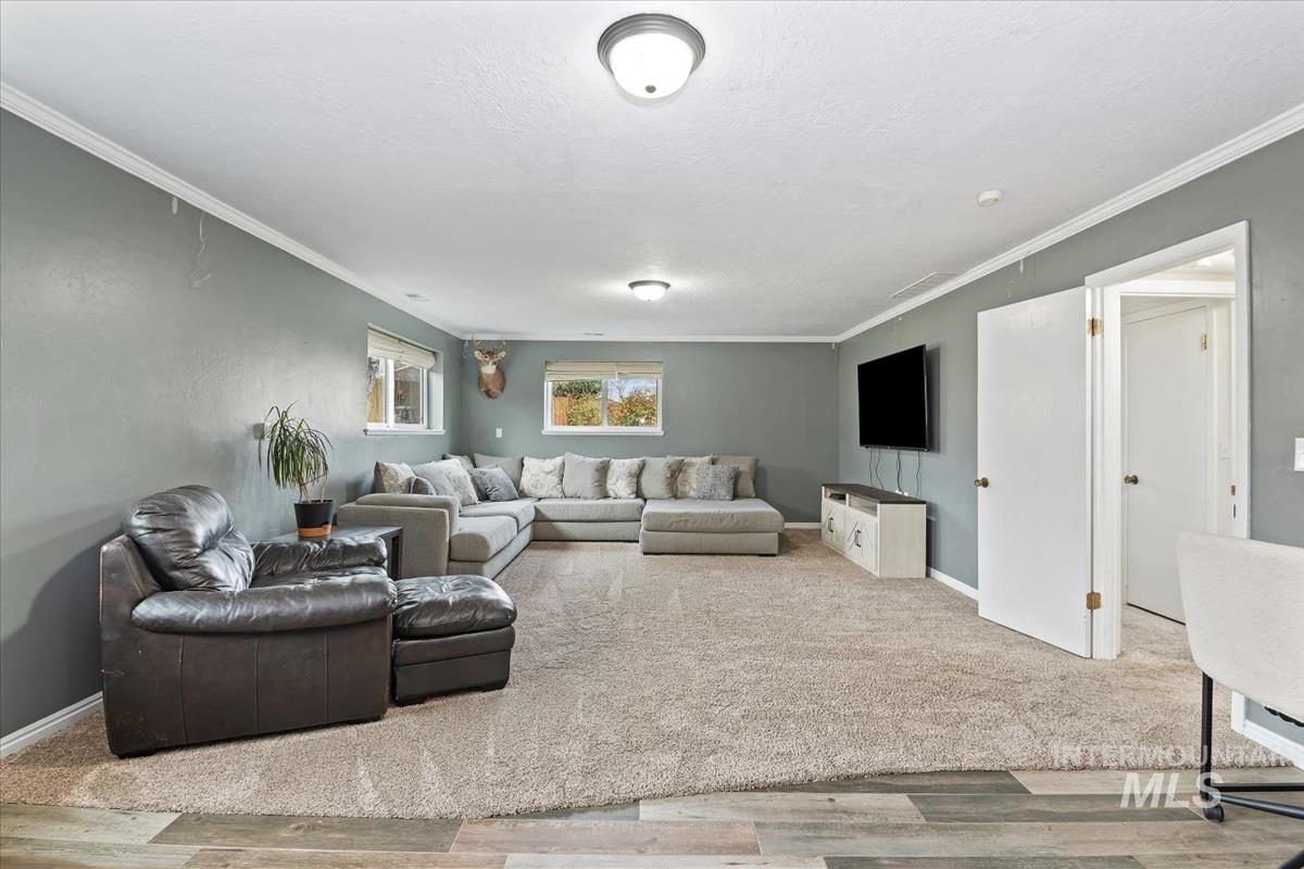Living room with ornamental molding and wood finished floors