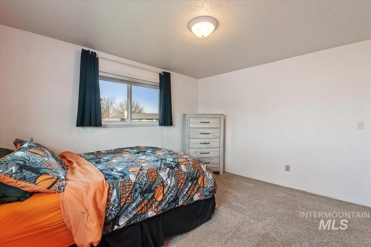 Carpeted bedroom featuring a textured ceiling
