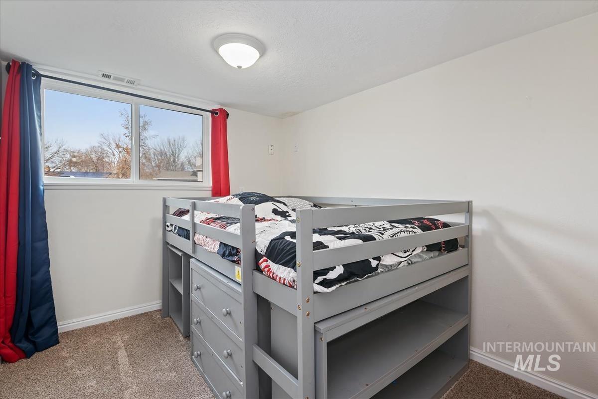 Bedroom with light carpet and baseboards
