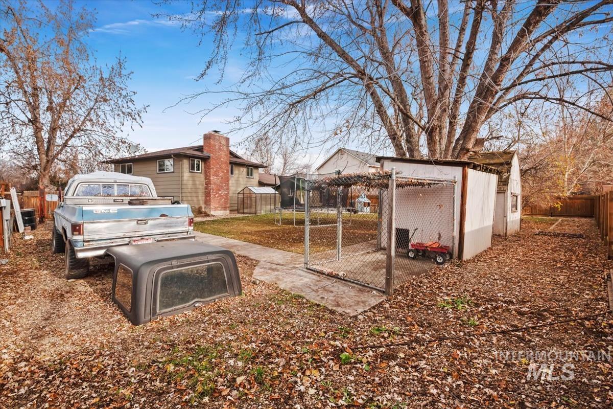 Fenced backyard with an outdoor structure and a patio area