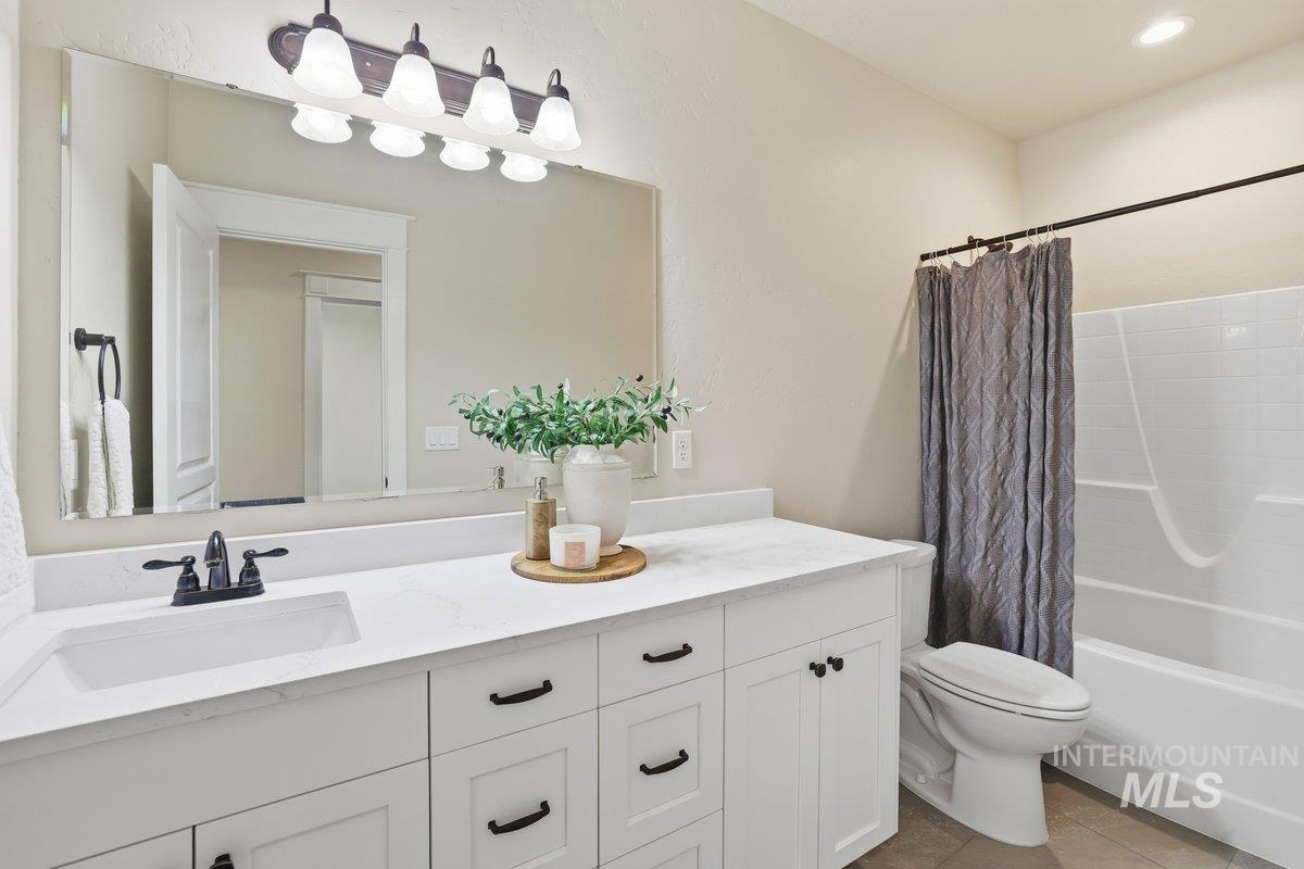 Bathroom with shower / tub combo, vanity, and light tile patterned floors