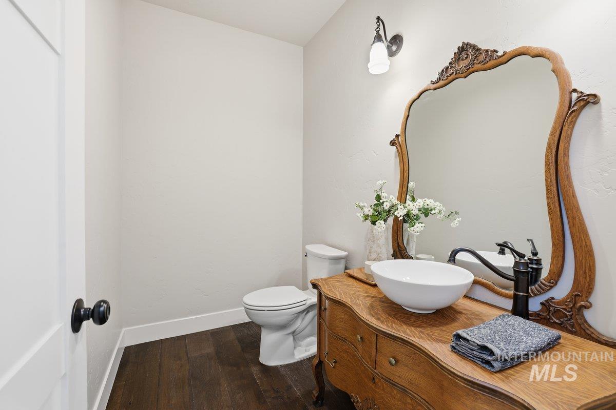 Half bathroom with vanity and dark wood-type flooring