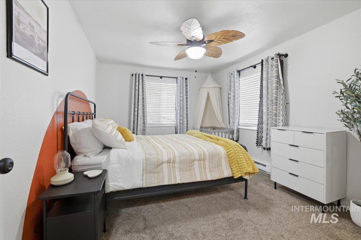 Bedroom featuring carpet flooring, a ceiling fan, and baseboard heating