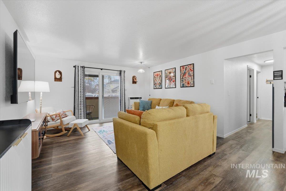 Living area featuring dark wood-style floors and baseboards
