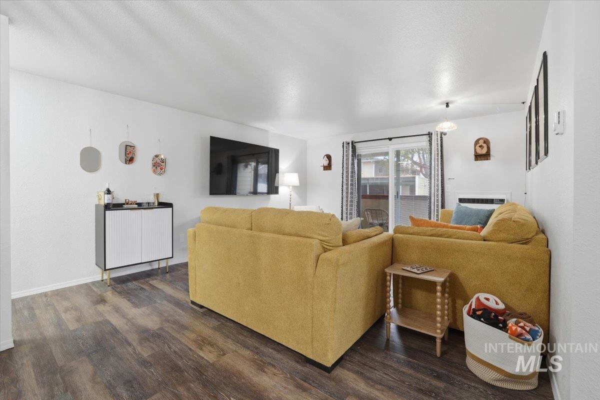 Living area featuring dark wood-type flooring and baseboards