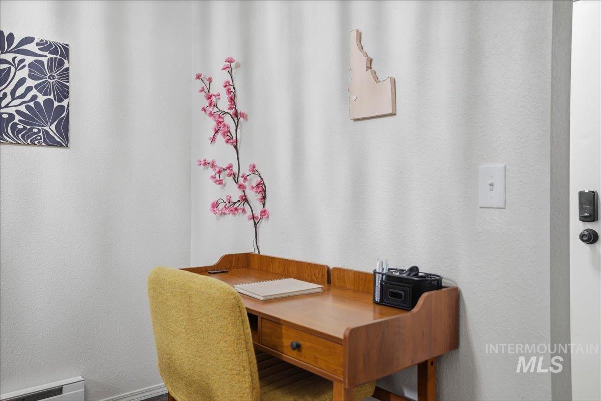 Office space featuring a textured wall and baseboard heating