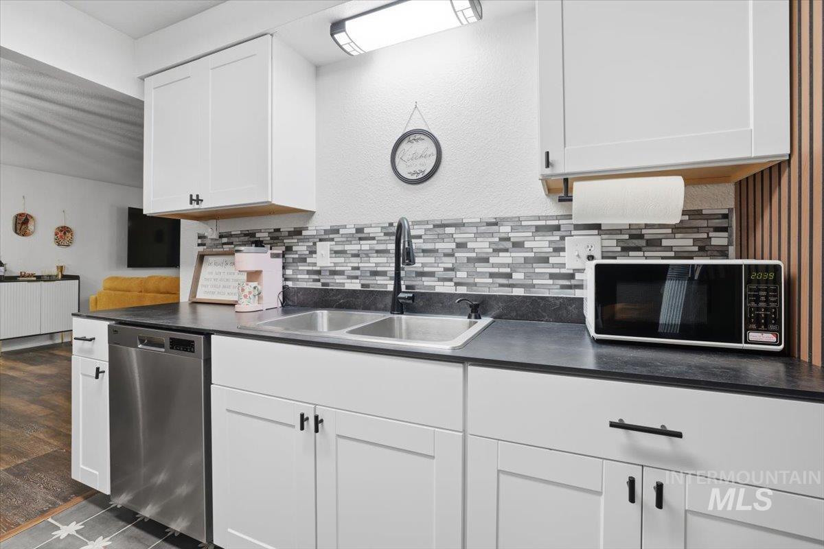 Kitchen with white cabinets, dark countertops, and stainless steel appliances