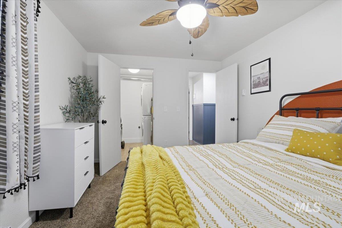 Bedroom with dark carpet, ceiling fan, and connected bathroom