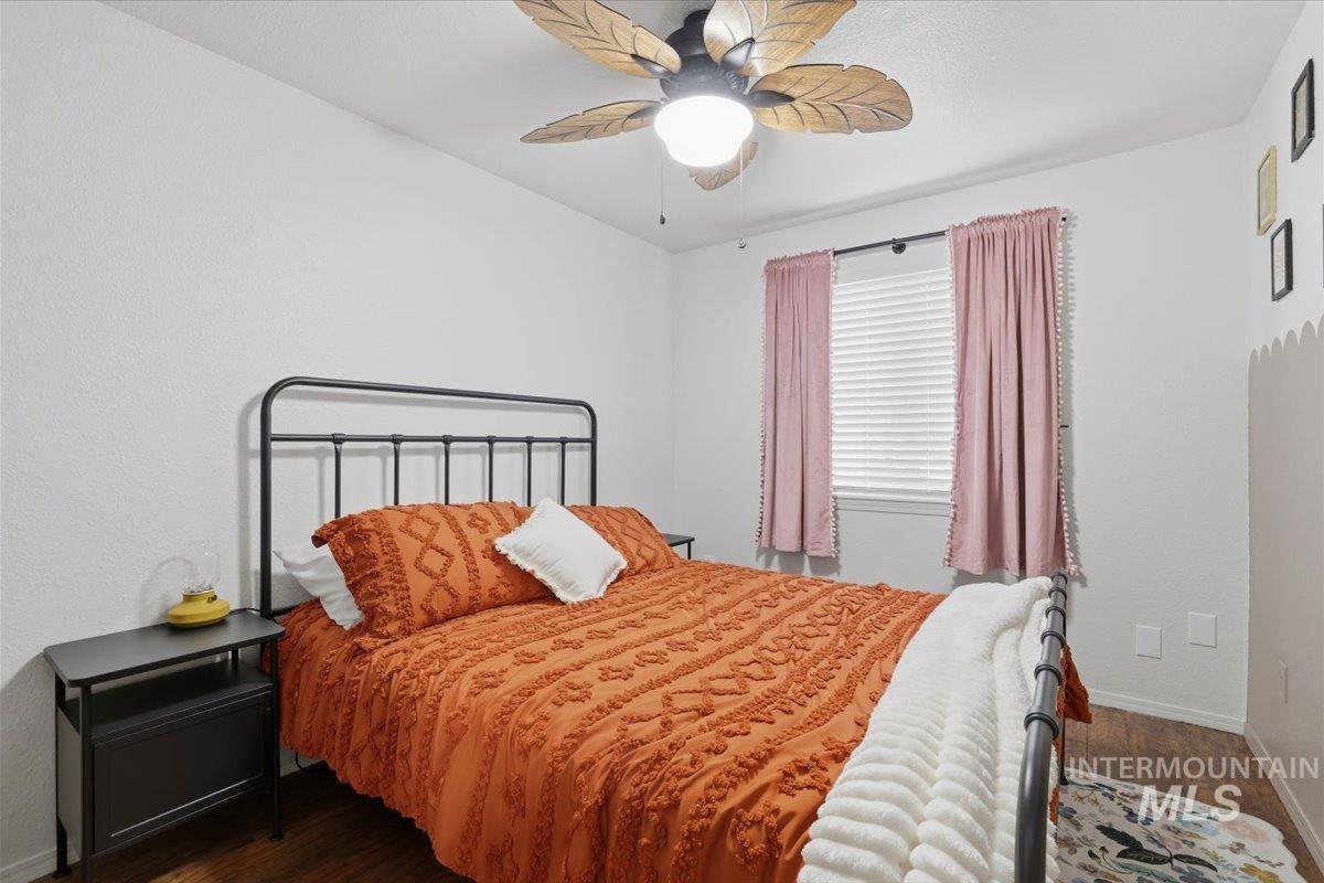 Bedroom featuring dark wood-type flooring and ceiling fan