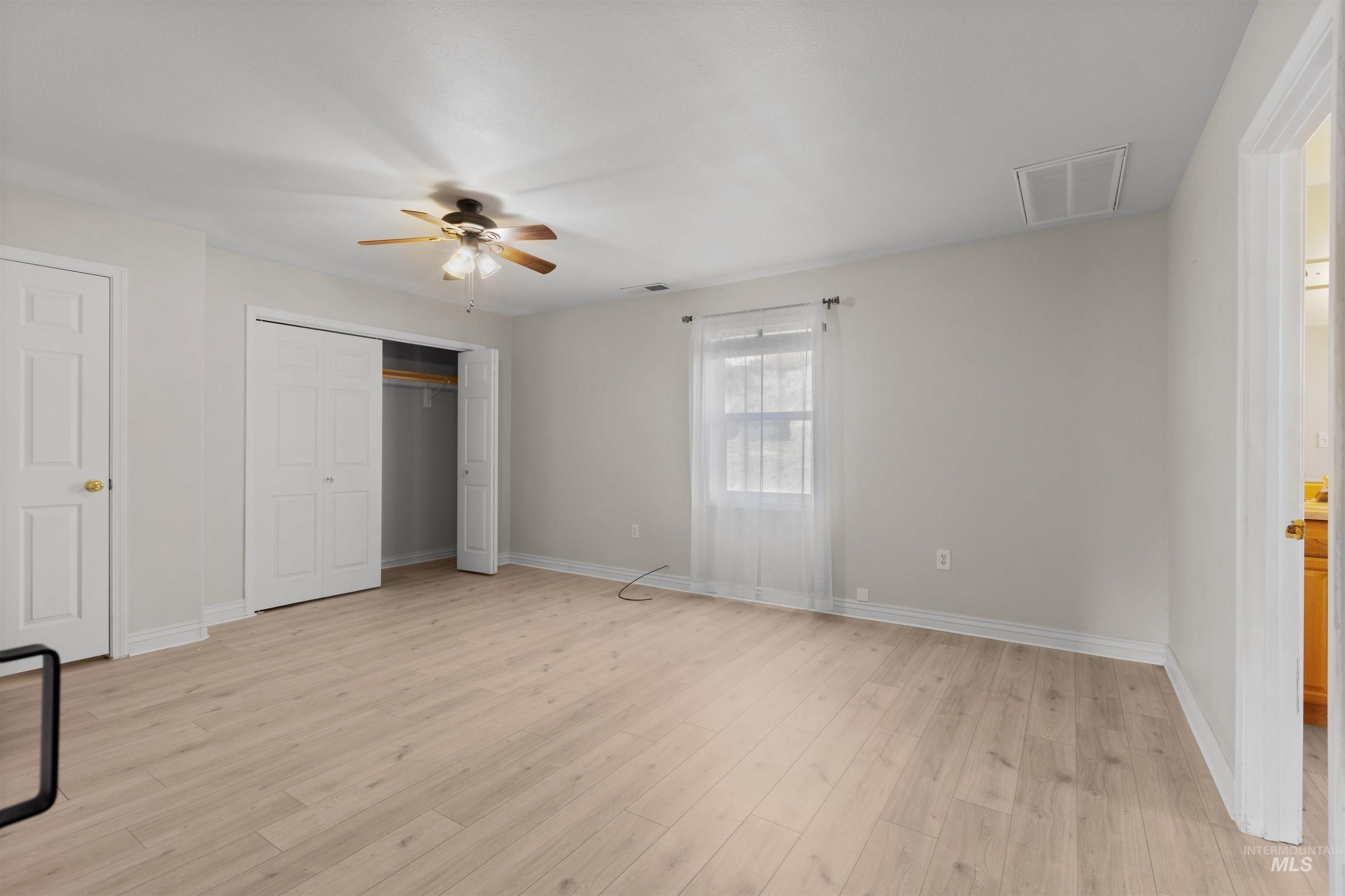 Unfurnished bedroom with light wood finished floors and ceiling fan