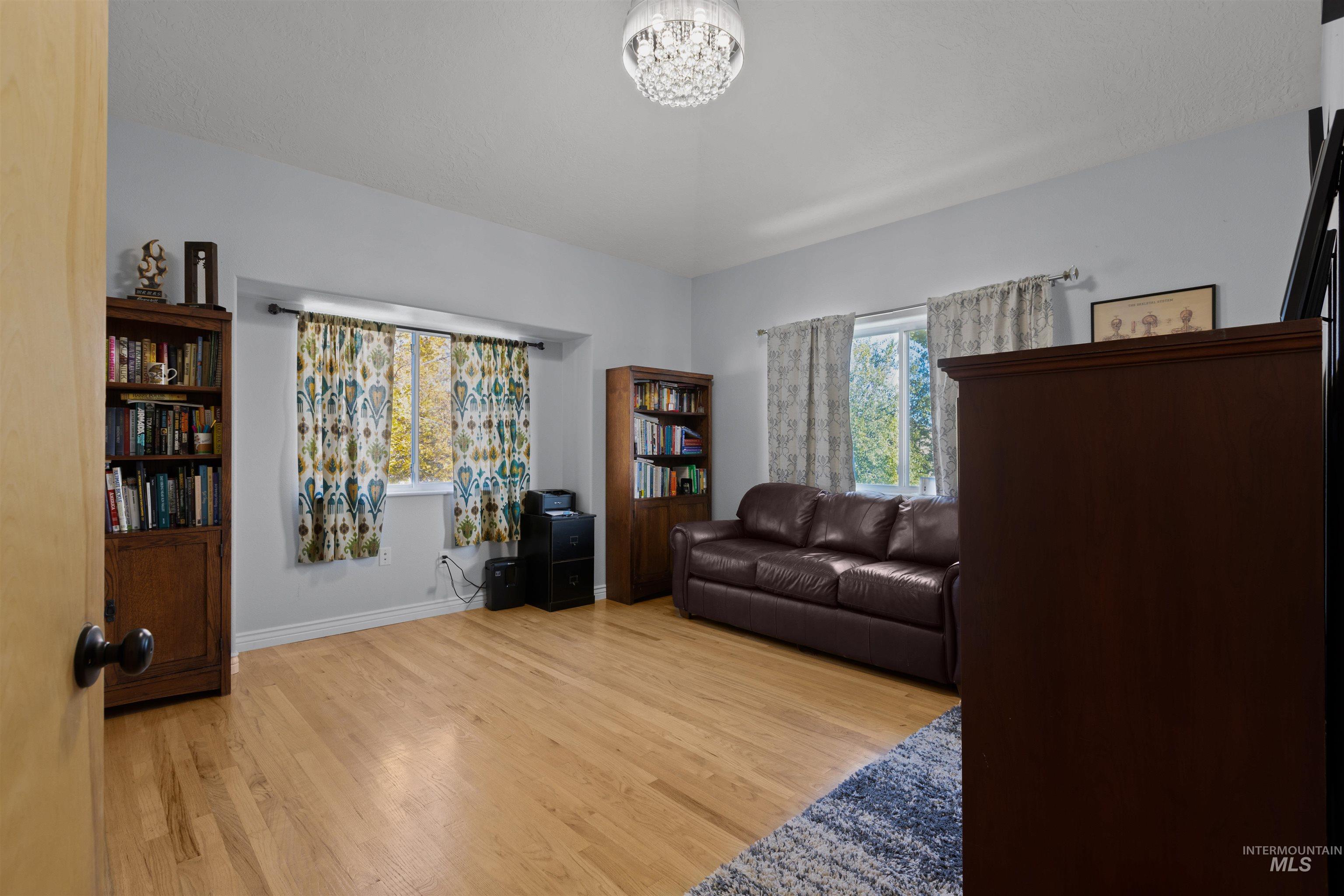Living area featuring light wood finished floors and a chandelier
