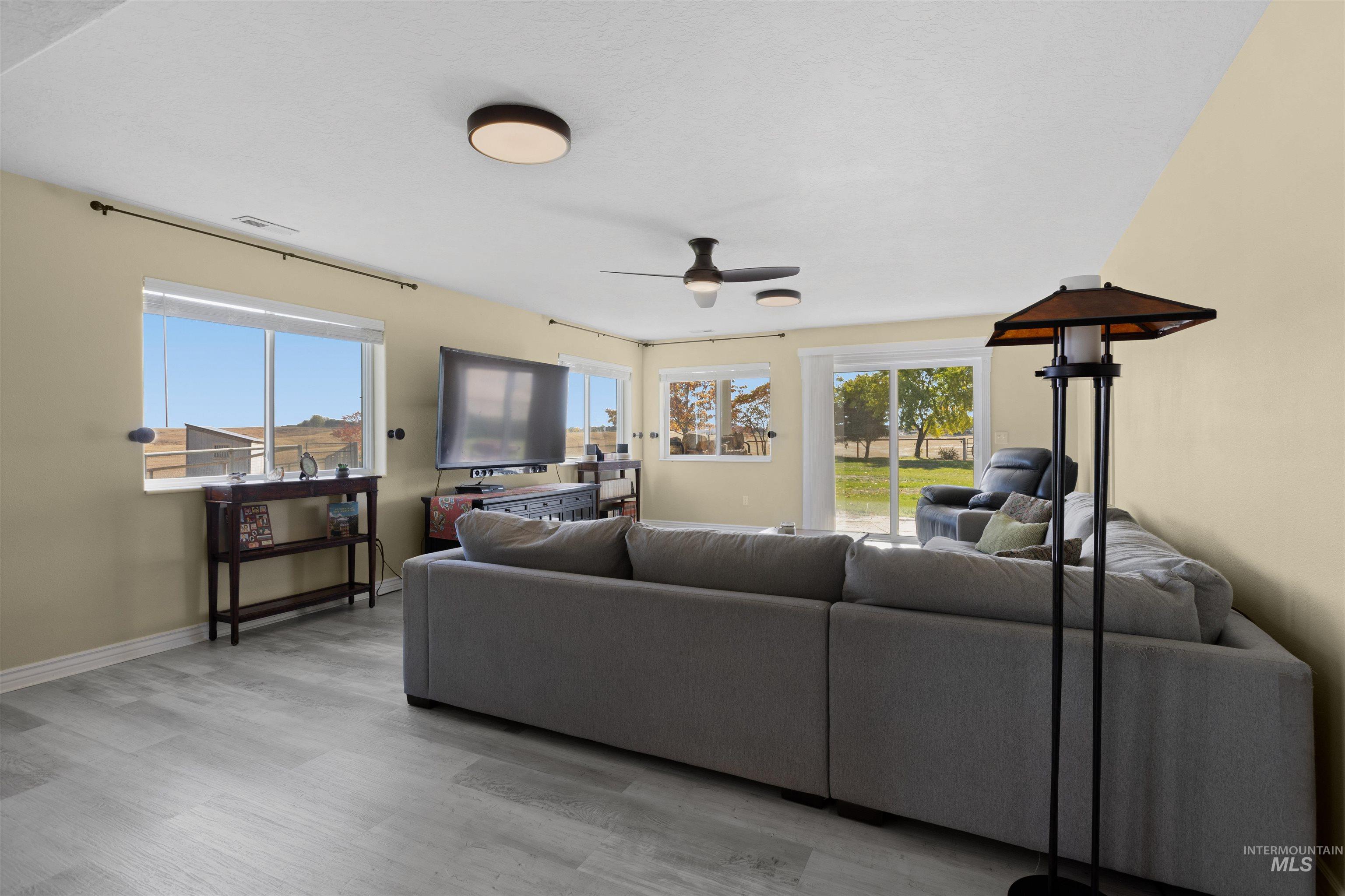Living area featuring light wood-type flooring and a ceiling fan