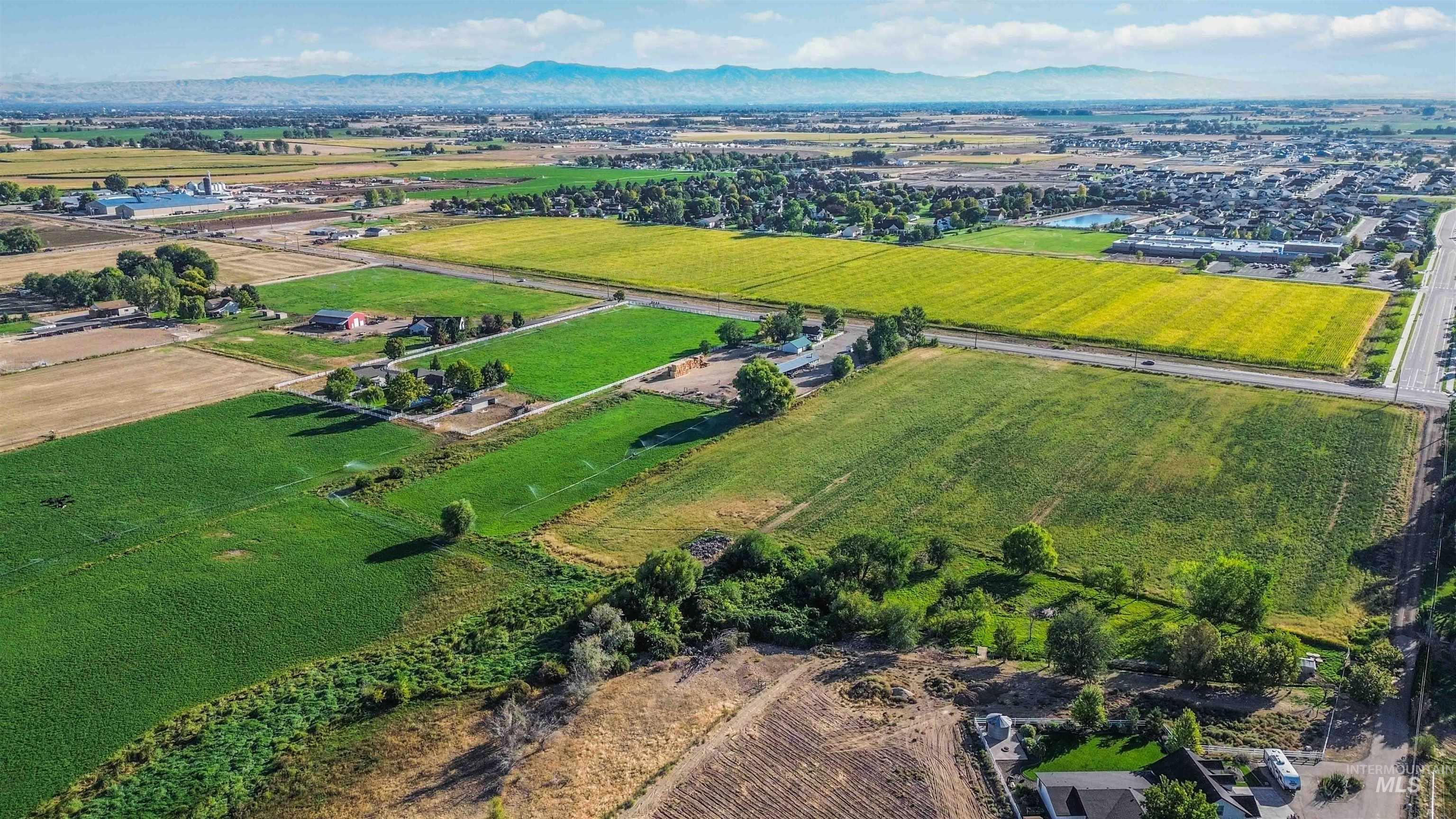 Aerial view of property and surrounding area with mountains and rural landscape