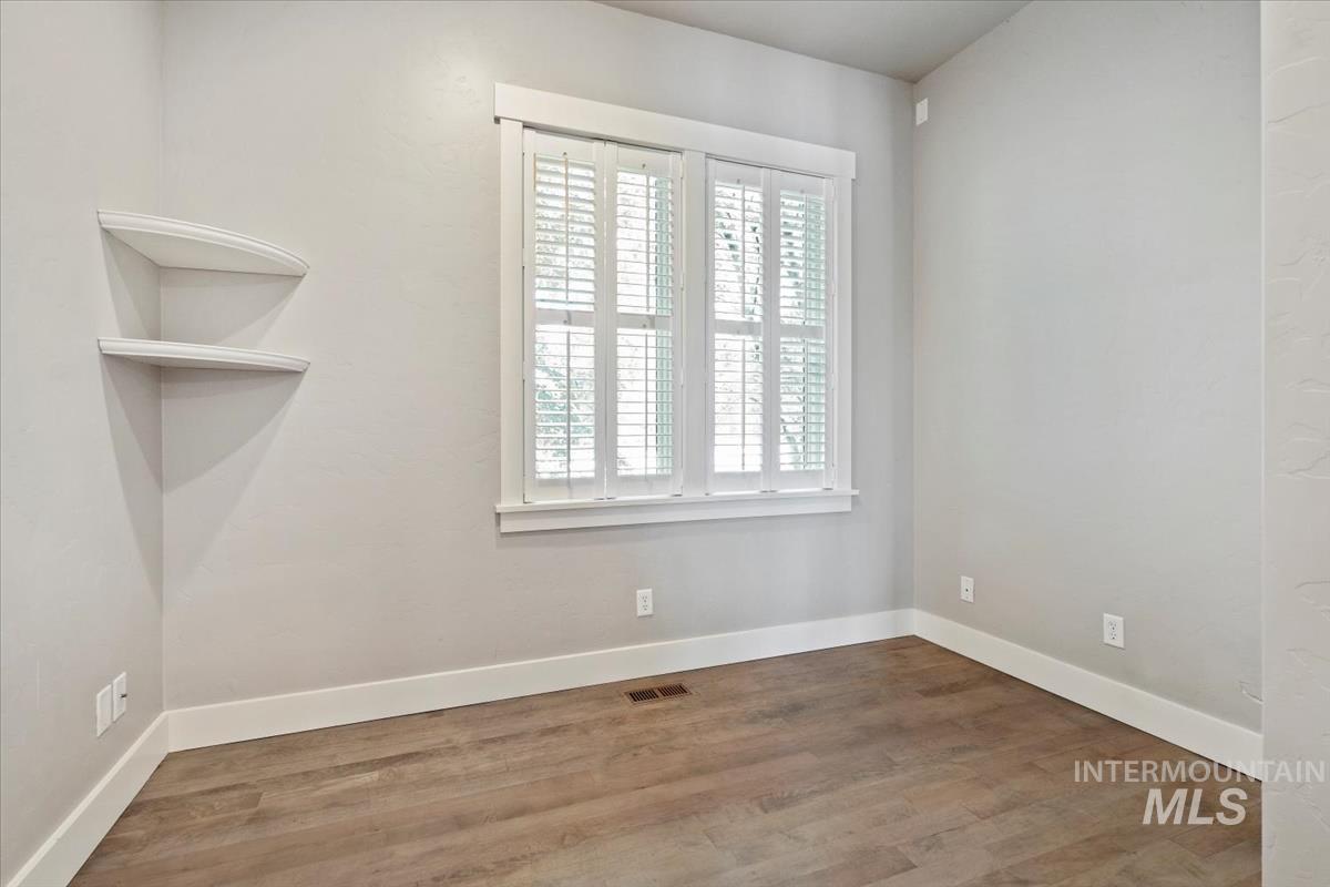 Unfurnished room featuring baseboards and wood finished floors