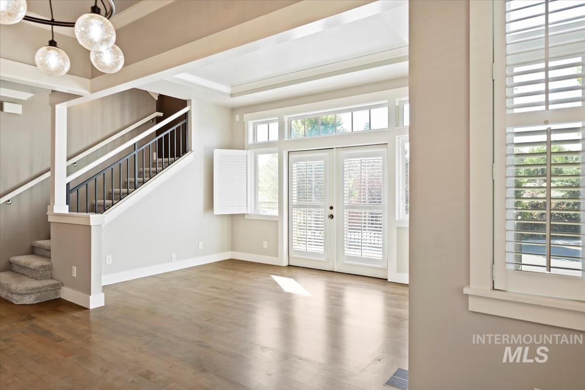 Foyer entrance with french doors, stairway, and wood finished floors