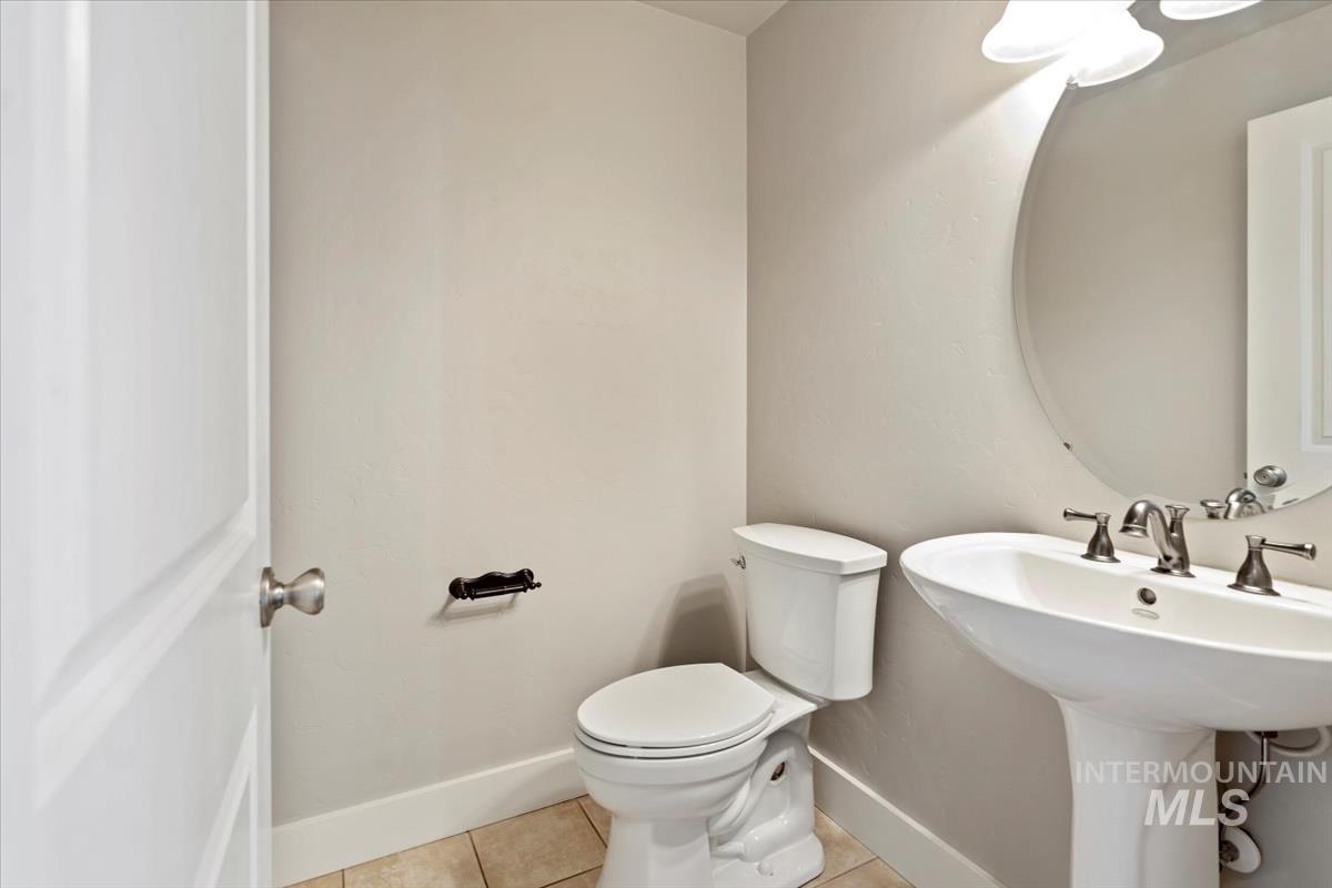 Half bathroom featuring light tile patterned flooring and toilet