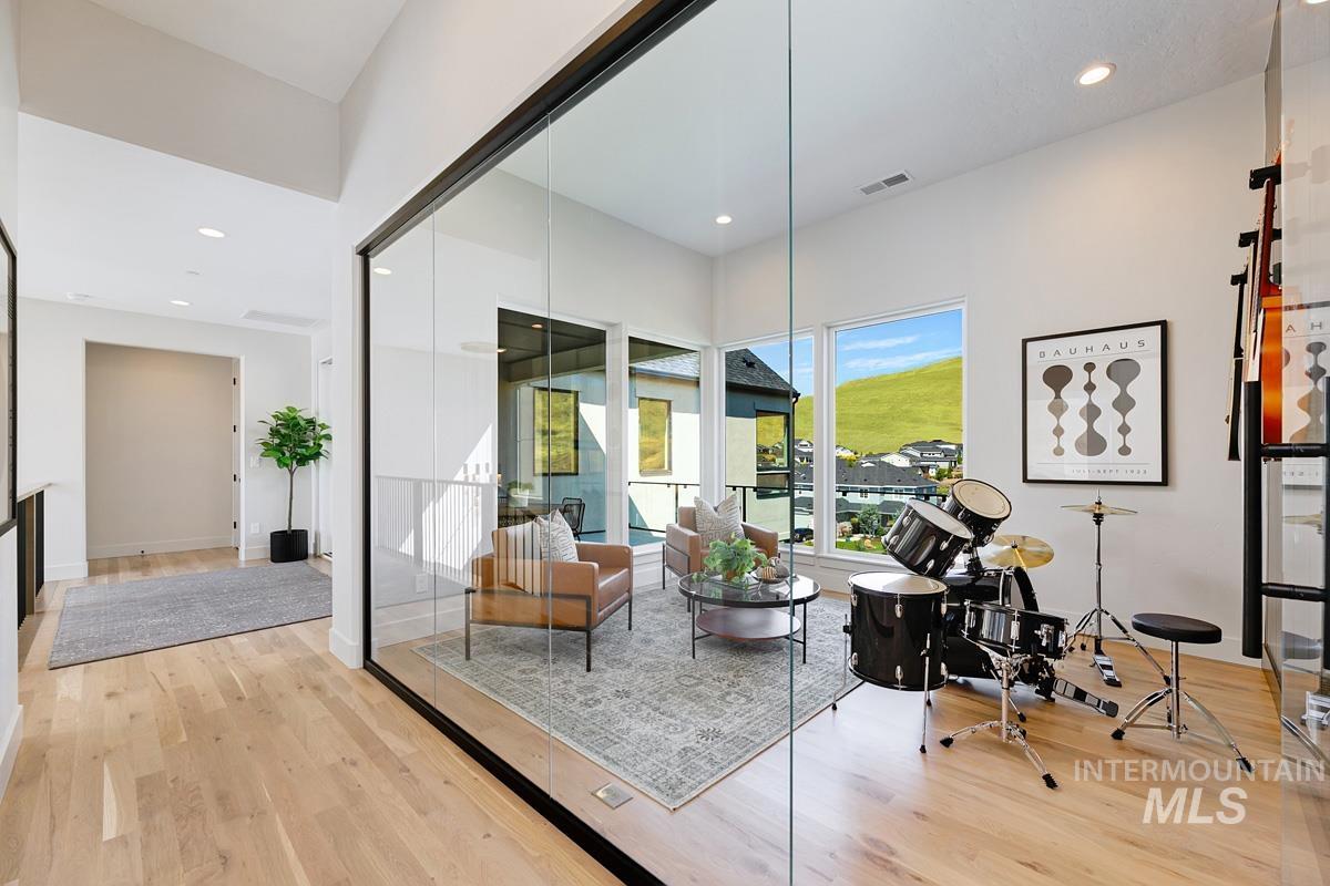 Glass-enclosed room featuring light wood-finish flooring, recessed lighting, and expansive windows