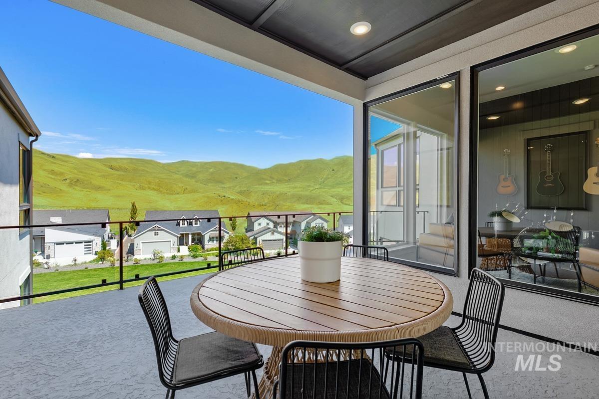 Covered balcony with a glass railing, showcasing distant green hills
