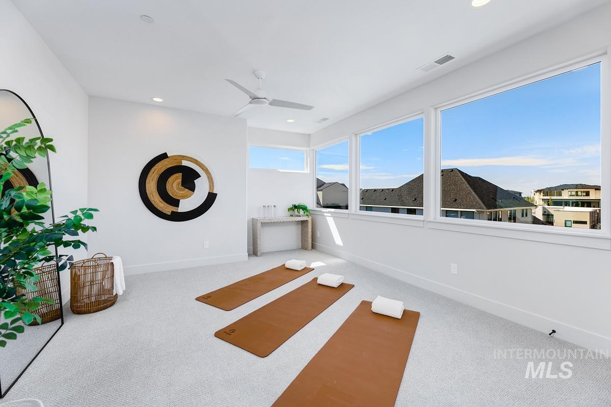 Bright room featuring expansive windows, recessed lighting, a modern ceiling fan, white baseboards, and light-colored carpeting