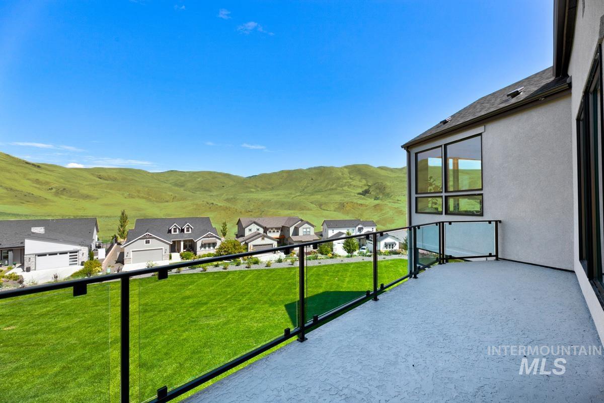 Exterior balcony featuring a textured concrete surface and glass panel railing