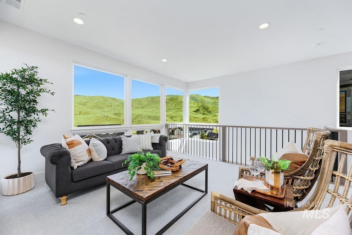 Bright upper-level bonus room featuring large windows showcasing green hills