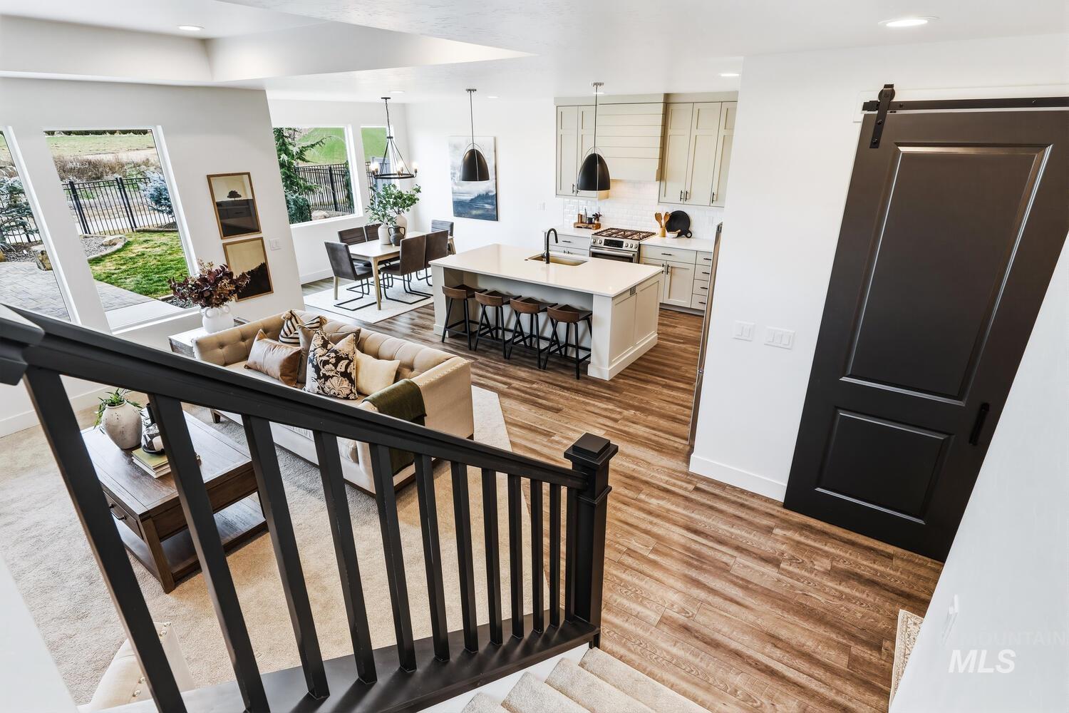 Stairway with a barn door, wood finished floors, and recessed lighting