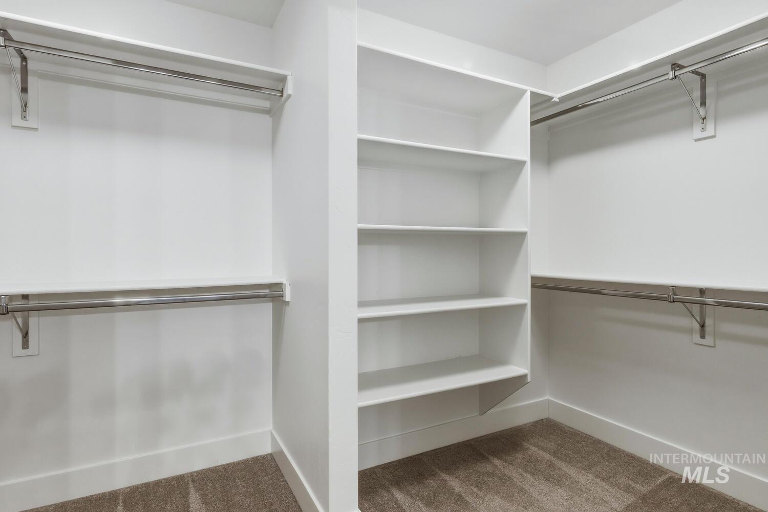 Walk in closet featuring dark carpet