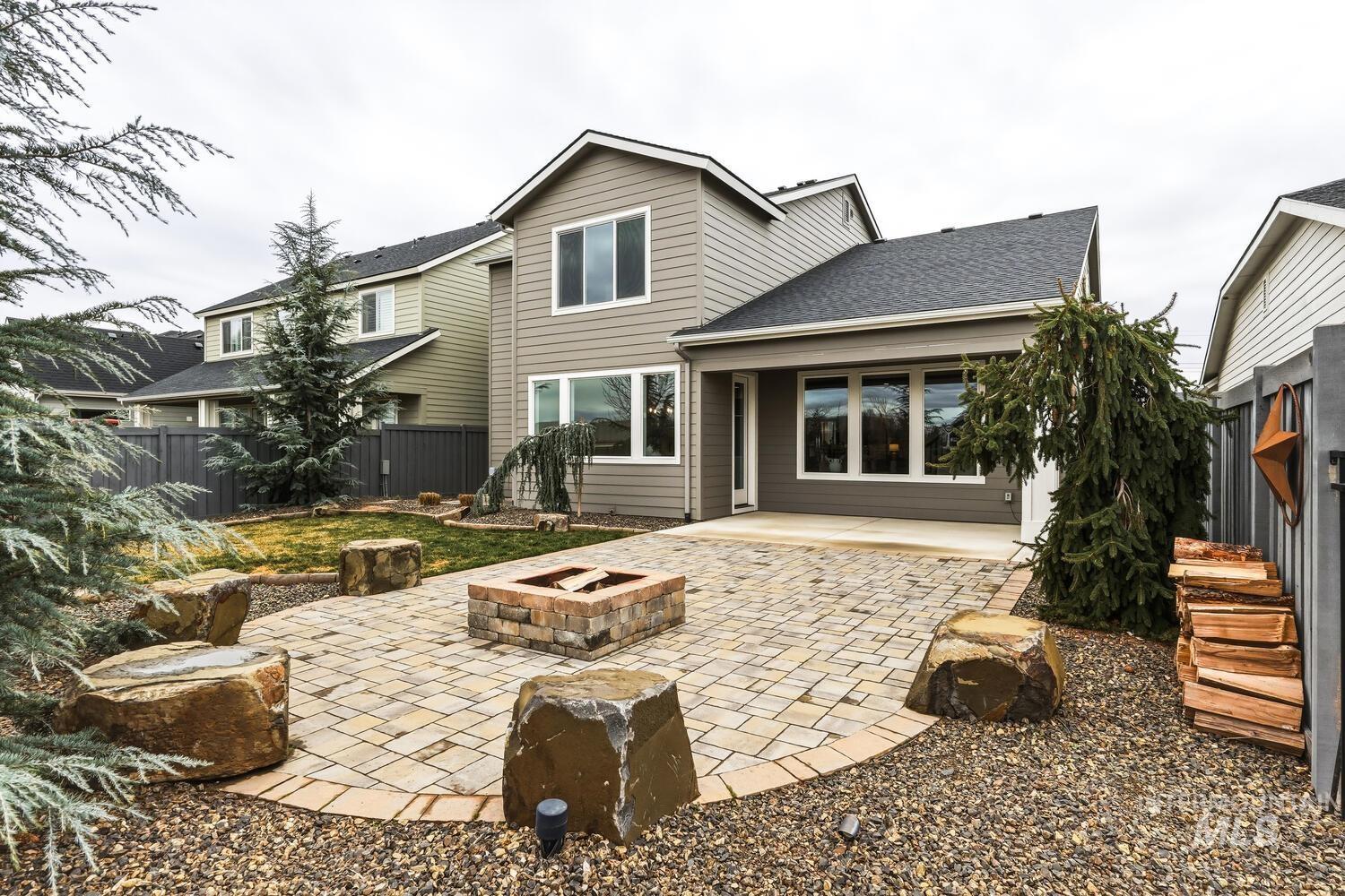 Back of property featuring a patio, an outdoor fire pit, and a shingled roof