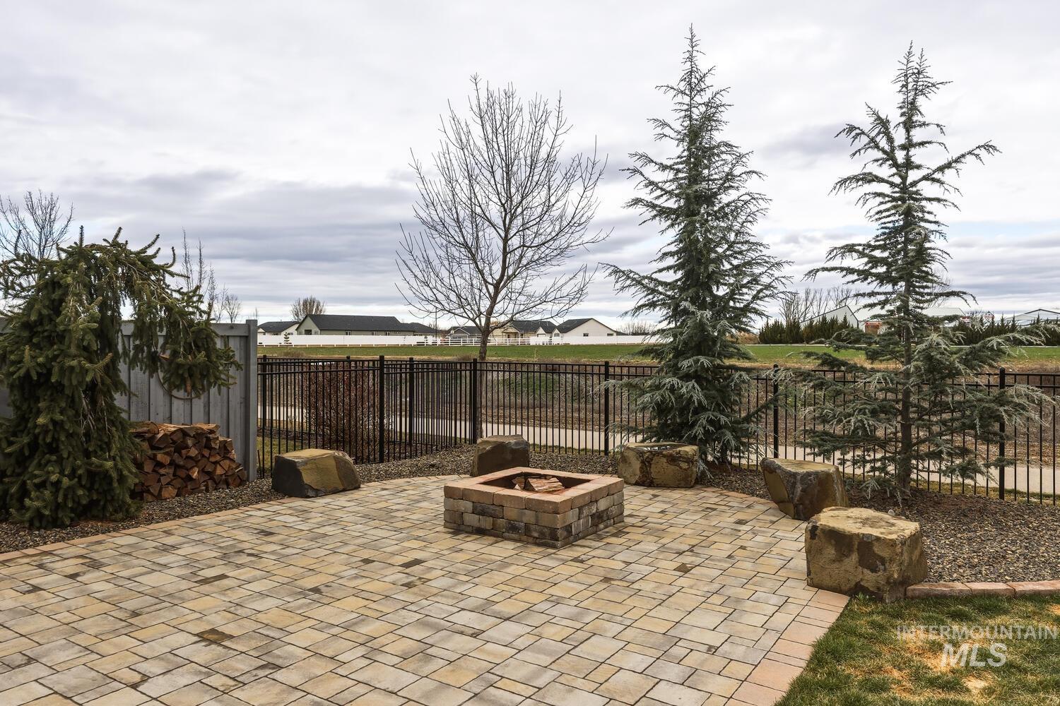 Fenced backyard featuring a fire pit and a patio area