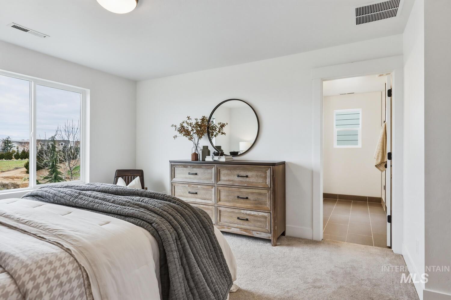 Bedroom with light colored carpet and baseboards