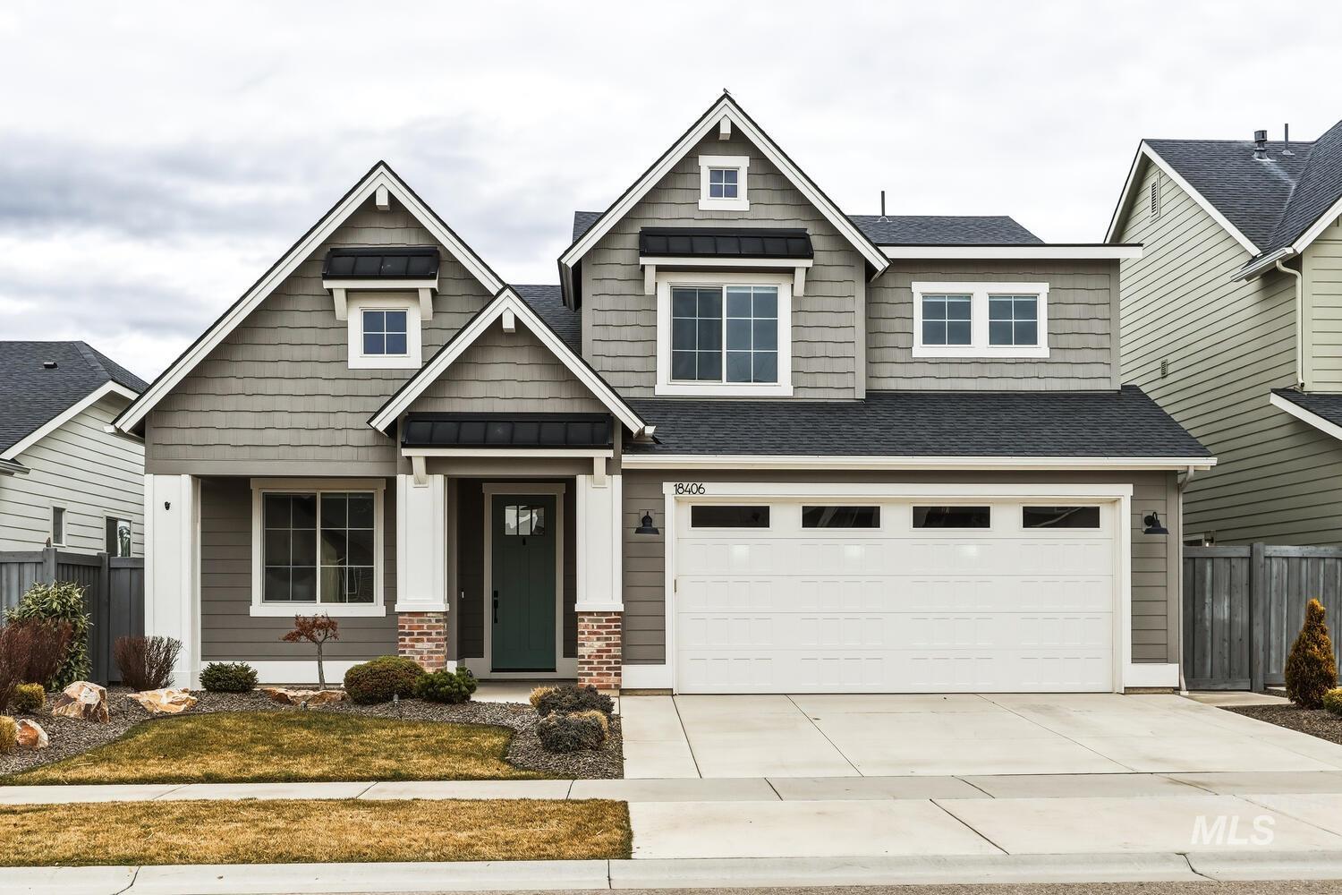 Craftsman house with driveway, a shingled roof, an attached garage, a standing seam roof, and brick siding